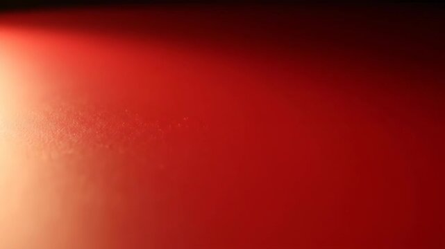 A warm, glowing red background with subtle texture. Soft light illuminates the left side of the frame.