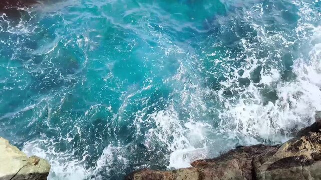 Turquoise ocean water with waves and white foam crashing against rocky shoreline, Roque de las Bodegas, Tenerife.