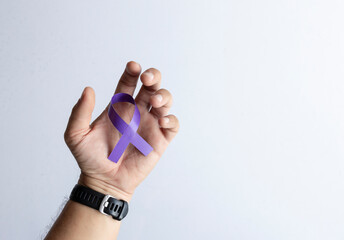 Hand Holding Purple Awareness Ribbon on White Background for Cancer Support Campaign