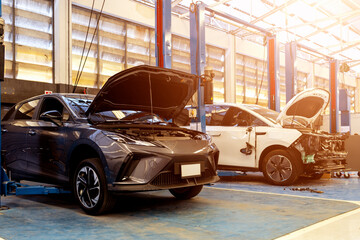 Modern white electric vehicle with side damage in a professional repair service center.