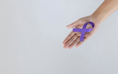 Hand Holding Purple Awareness Ribbon on White Background for Cancer Support Campaign