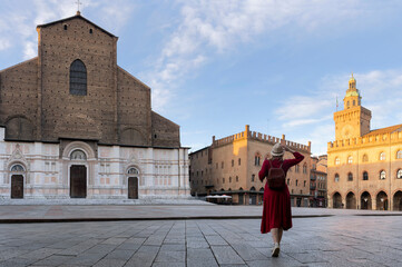 Obraz premium Young tourist dressed in red in front of central square near San Petronio basilica in Bologna city - Italy