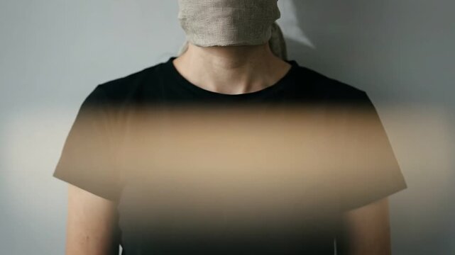 Woman with a cloth over her mouth, symbolizing censorship, silence, and oppression