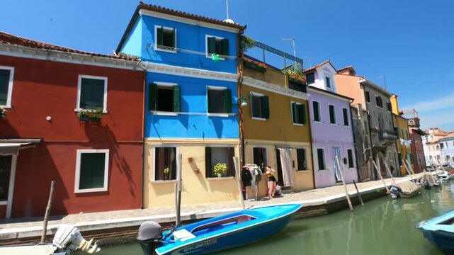 Coloured houses of Burano. A view along Fondamenta Pontinello Sinistra and Destra footpaths in Burano. Boats moored in the waterway.