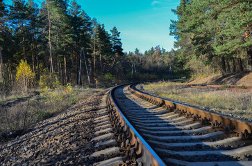 Atmospheric railway curve passing through a misty coniferous forest at sunrise. © Dmytro