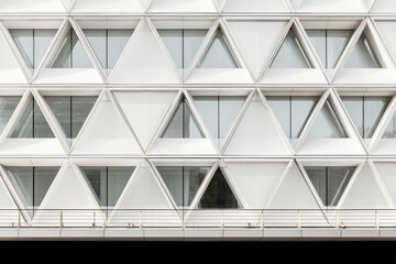 Modern building facade with shaped geometric structure and glass windows.