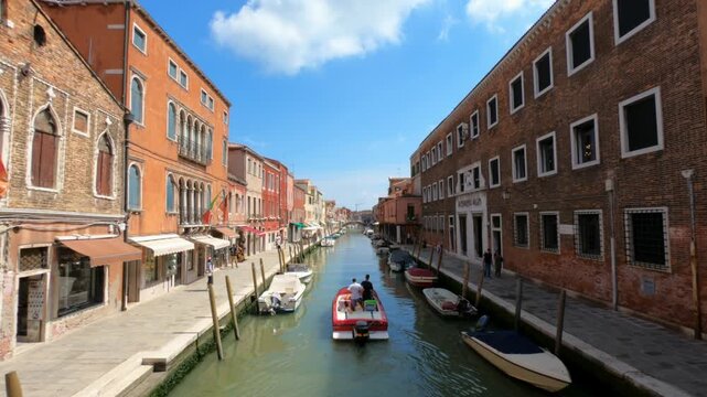 Murano / Venice / Italy - June 23, 2019: A view along Fondamenta Dei Vetrai and Fondamenta Daniele Manin footpaths in Murano. Boats rest along the side.
