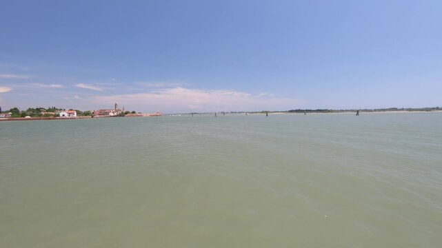 Mazzorbo / Venice / Italy - June 23, 2019: Beautiful landscape of Mazzorbo seen from a boat ride on a sunny day. Stabilized Shot of Venetian Lagoon in Italy from tourist boat.