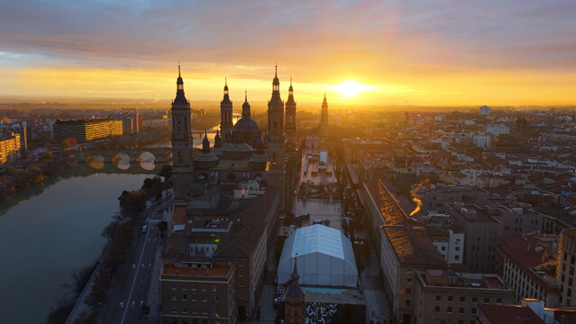 Aerial View Capturing Sunset Glow Illuminating Cathedral Domes And Tranquil River Reflections. Zaragoza. Spain 