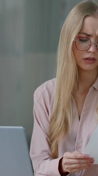 Caucasian business woman with laptop working confused checking paper documents mistake female girl businesswoman manager worker difficult job online with computer and paperwork at table at home office