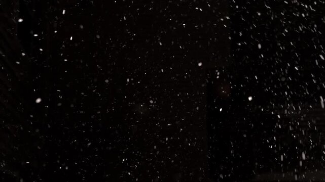 Pure real snowfall with dynamic variable winds against black sky. Snowflakes move naturally in 4K detail, isolated background perfect for seamless compositing and VFX integration.