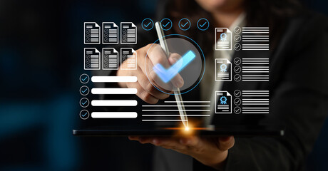 A professional woman uses a digital tablet to manage documents and checklists. The image...