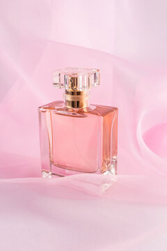 Elegant perfume bottle on soft pink organza fabric