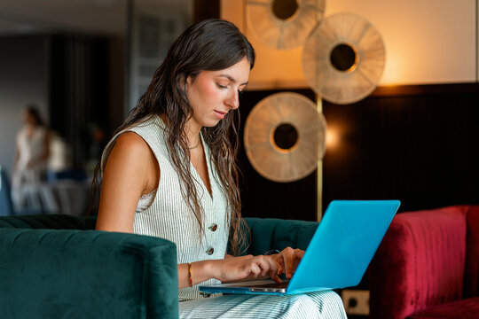 Woman working on a laptop in a hotel lobby