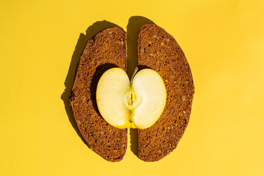 Creative food art with apple and bread on yellow