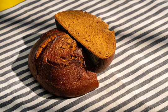 Dark rye bread on striped cloth background