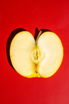 Minimalist apple slice on vibrant red background