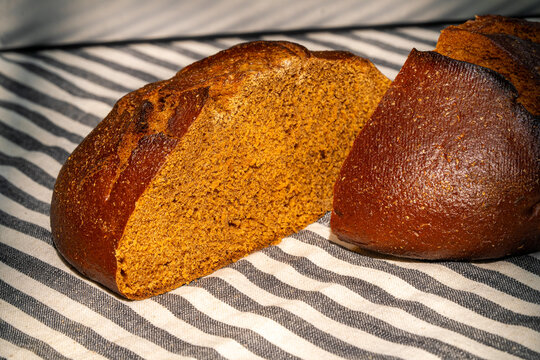 Freshly baked rye bread on striped cloth