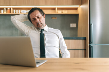Exhausted businessman leaning back in home office chair tired after work