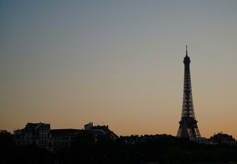 Sunset over the Seine River with Eiffel Tower in Paris &ndash; Romantic evening skyline with golden sky and reflections on the water