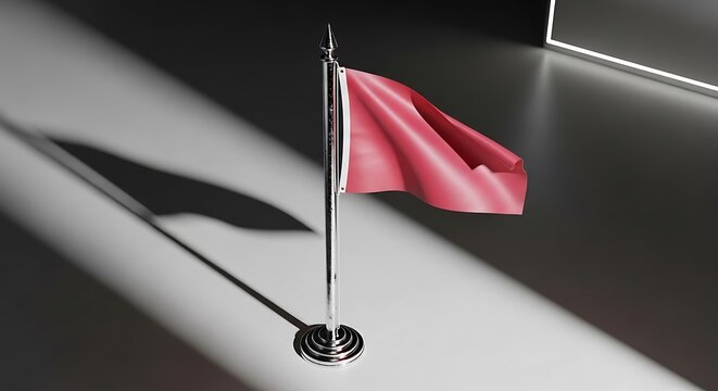 A red flag attached to a thin pole casting a shadow on a dark surface