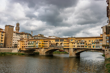 Obraz premium Famous historic Ponte Vecchio bridge and old buildings along the Arno river in Florence Italy