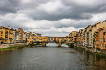 Fototapeta premium Famous historic Ponte Vecchio bridge and old buildings along the Arno river in Florence Italy