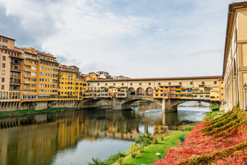 Fototapeta premium Famous historic Ponte Vecchio bridge and old buildings along the Arno river in Florence Italy
