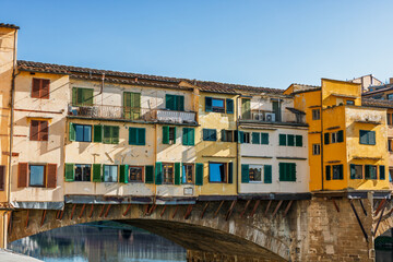 Obraz premium Famous historic Ponte Vecchio bridge and old buildings along the Arno river in Florence Italy
