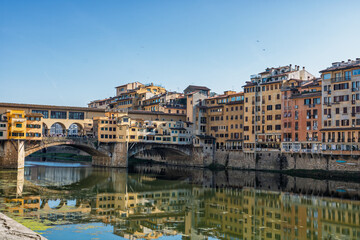 Obraz premium Famous historic Ponte Vecchio bridge and old buildings along the Arno river in Florence Italy
