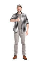 Fototapeta premium Smiling long-haul truck driver in baseball cap and checkered shirt showing thumbs up on white background