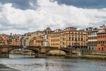 Fototapeta premium Famous historic Ponte Vecchio bridge and old buildings along the Arno river in Florence Italy