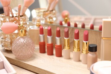 Different makeup products on wooden table, closeup