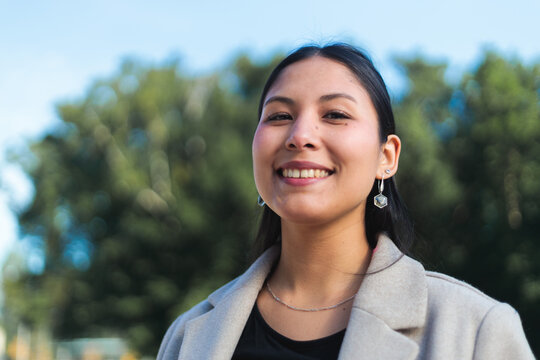 Confident Young Woman Smiling Outdoors in Natural Light