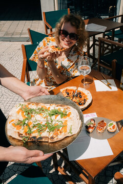 Delicious Dining Experience With Pizza and Wine at a Sunny Cafe