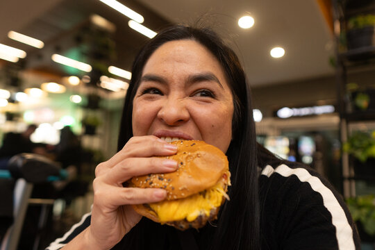 Enjoying a Delicious Burger in a Bustling Food Court