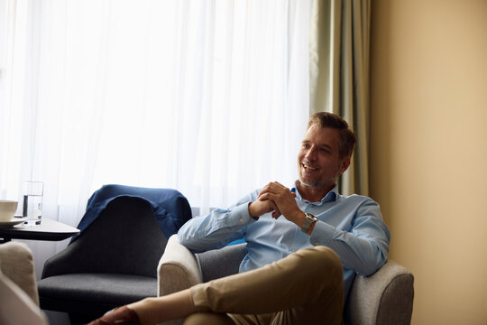 Elegant man sits a hotel room
