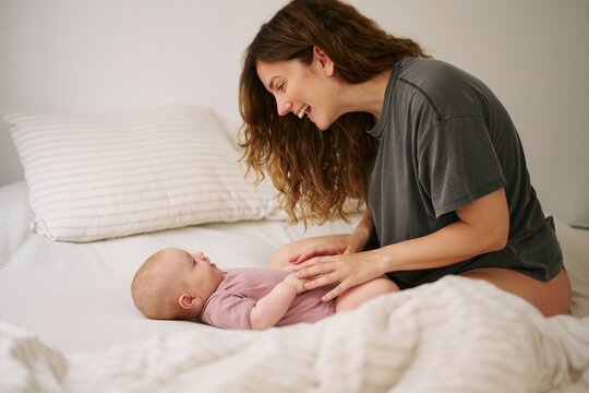 Mother joyfully engages her baby in a cozy home setting