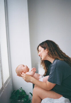 Mother plays with baby in the bedroom