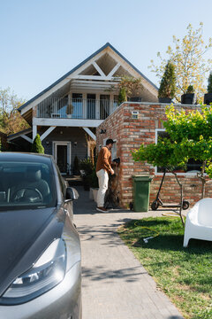 The man connects the charger to the electric car