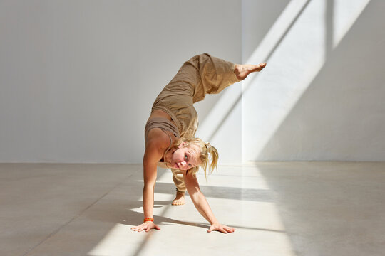 Dancer performs intricate moves in a sunlit studio