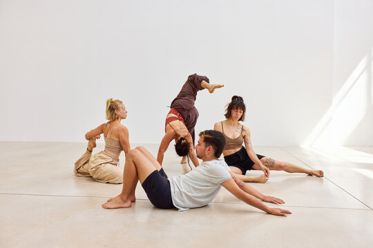 Group of dancers practicing contemporary movement in bright stud