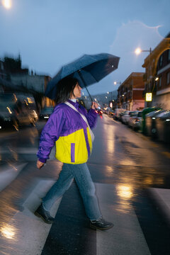 Woman Crossing Rainy Street at Night
