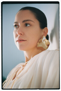 Portrait of young beautiful woman wearing golden earrings