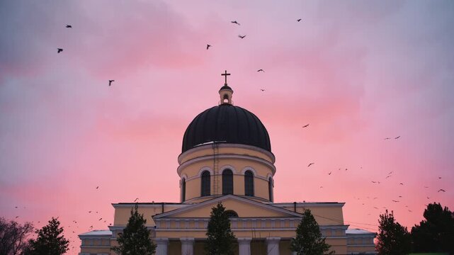 Exterior view of the Nativity Cathedral topped with a cross against a soft pink and blue sunset sky, Chisinau, Moldova