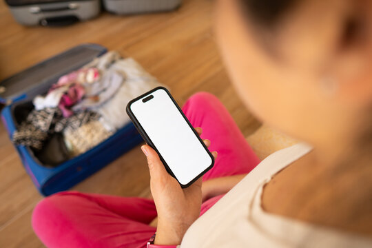 Preparing for Travel While Checking a Smartphone at Home