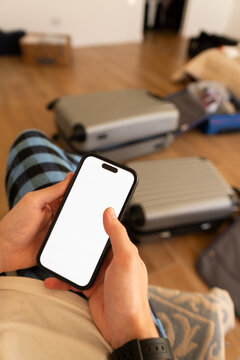 Preparing for Travel With Luggage and a Smartphone in Hand