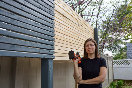 Woman building a wooden fence