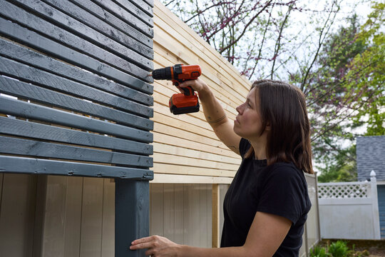 Woman building a wooden fence