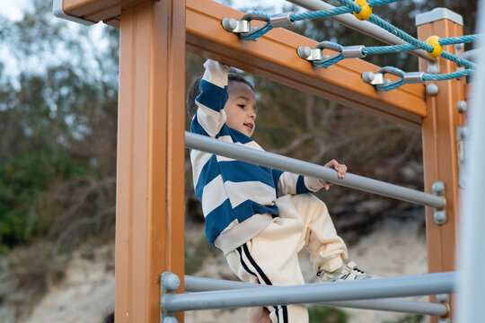 Child Climbing Playground Structure Outdoors
